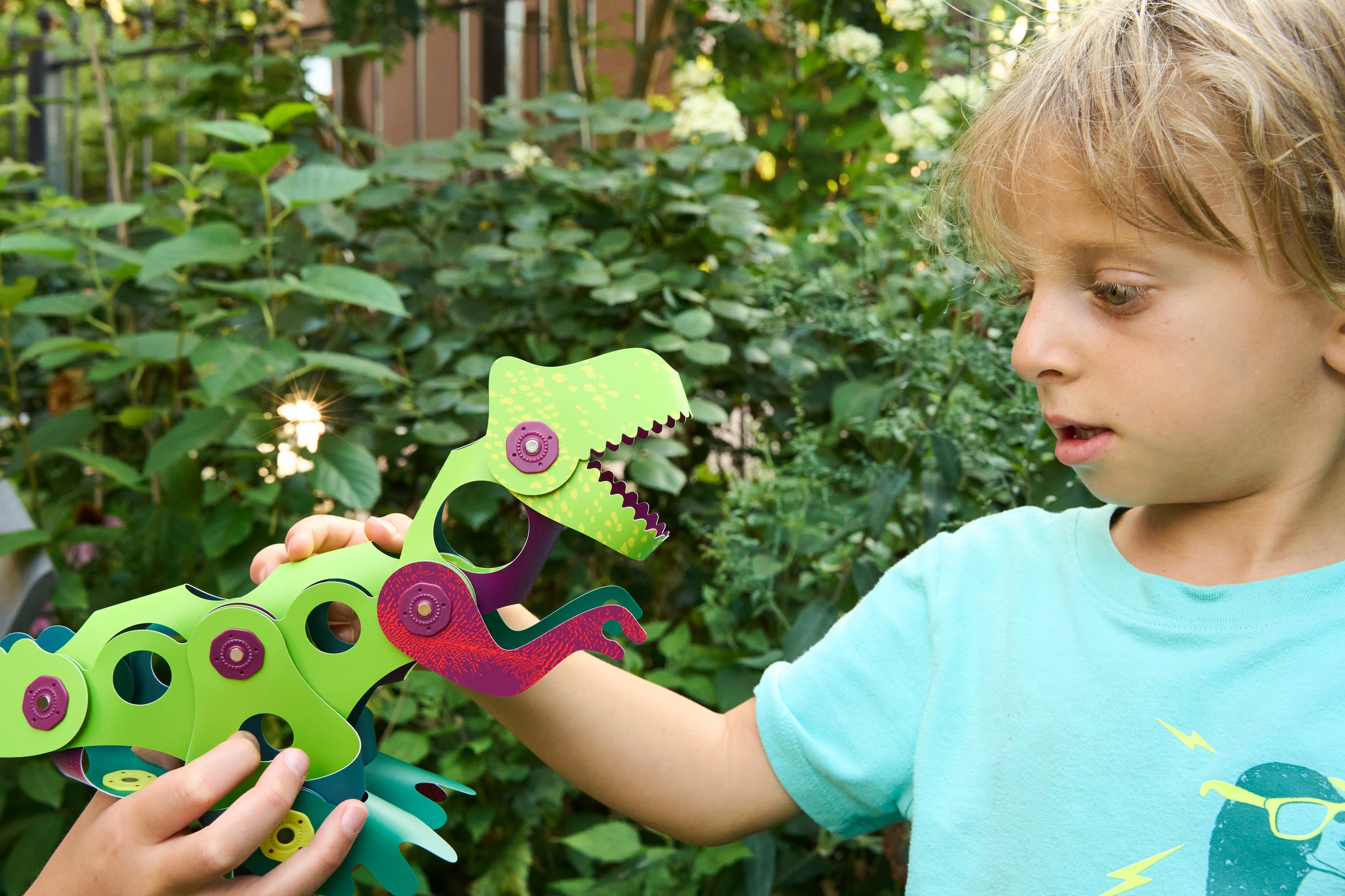 Montessori-inspired Jurassic green and pink patterned dinosaur magnetic builder shapes for open-ended play.