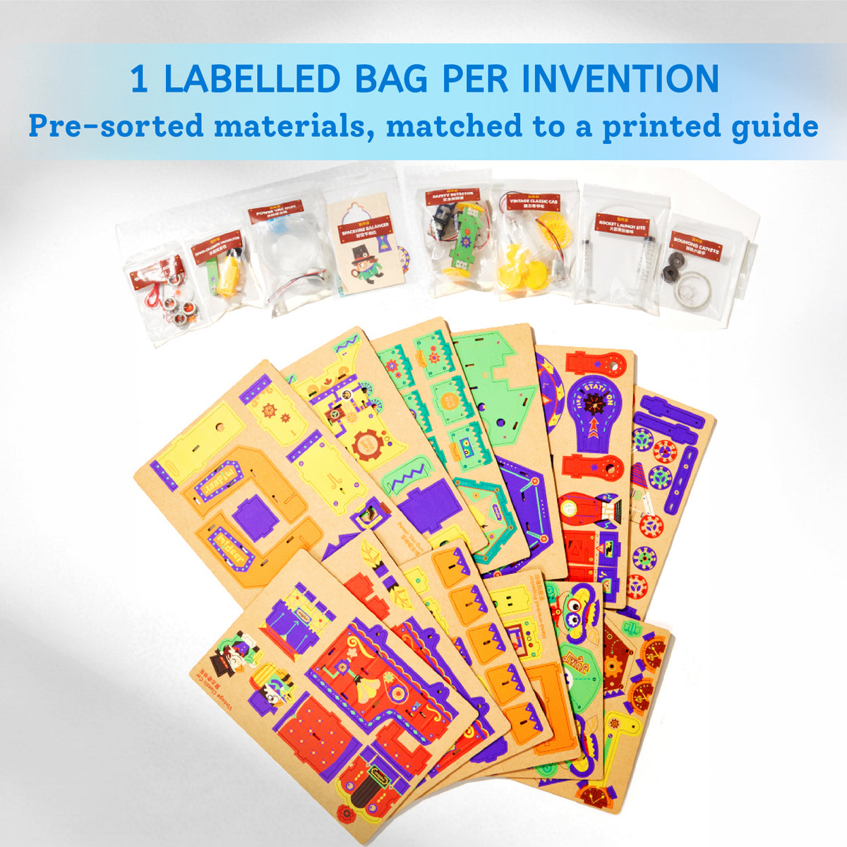 A children's craft or science kit shown on a white background with text at the top reading '1 LABELLED BAG PER INVENTION' and 'Pre-sort materials, matched to a printed guide.' Several small clear plastic bags with colorful contents are lined up, and multiple wooden activity boards with printed colorful layouts are fanned out below.