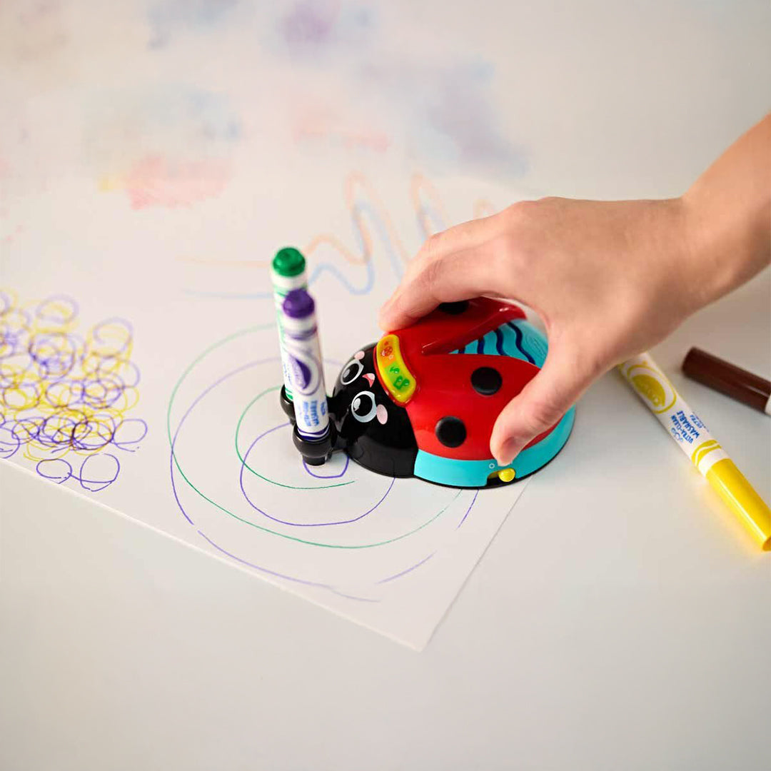A child drawing with the Doodle Bug on a large sheet of paper, showing colors and sounds
