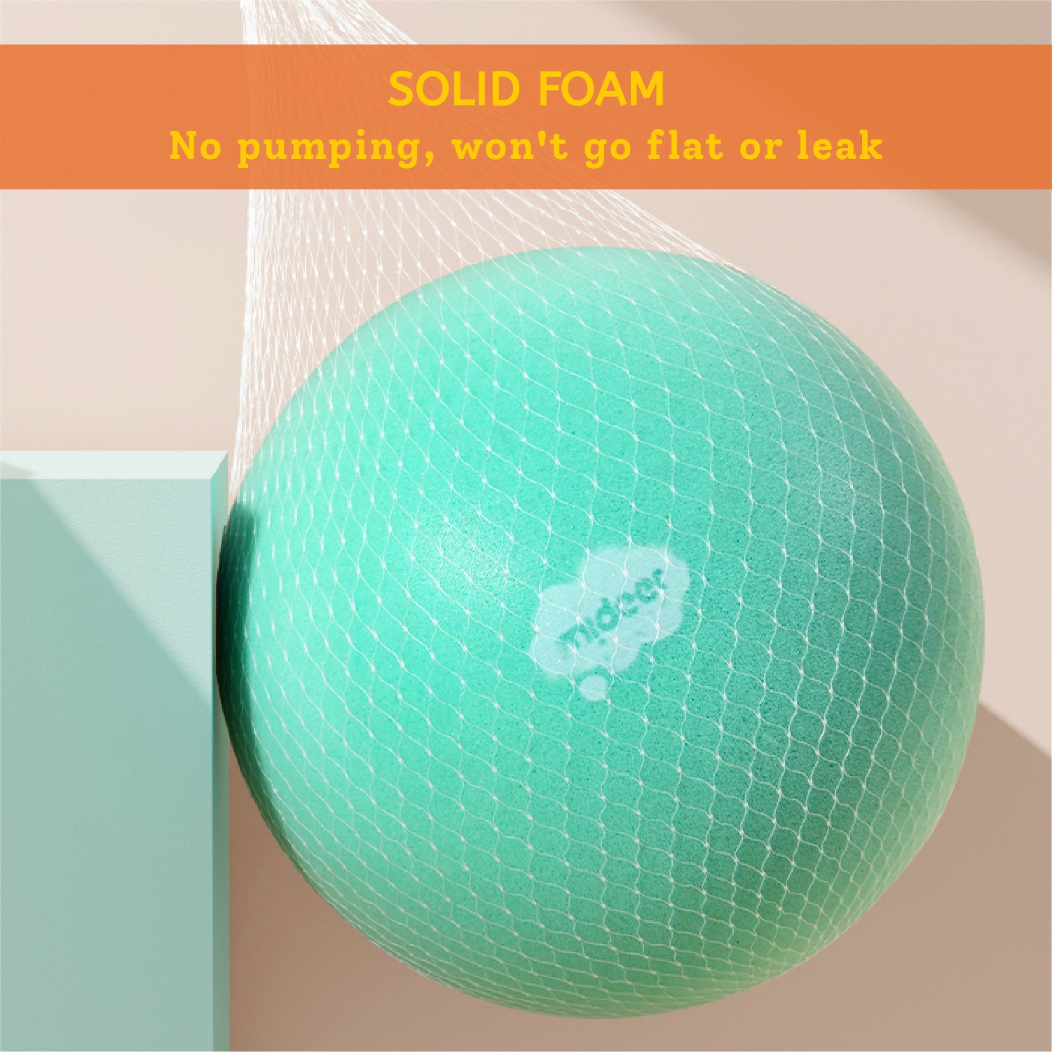 A mint green midcer solid foam baby support ball with a honeycomb texture, shown hanging from a white mesh bag next to a light teal block. An orange banner at the top reads 'SOLID FOAM No pumping, won't go flat or leak'.