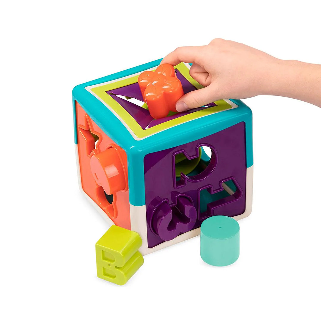 A detailed view of the activity sides of the Battat Shape Sorter Cube, showing the colorful bead maze and interlocking spinning gears designed for sensory play.
