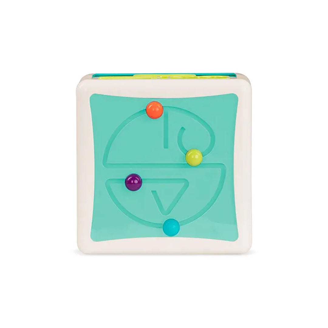 A child's hand easily retrieving colorful shape blocks from the bottom of the Battat Shape Sorter Cube through the soft, flexible access flaps.