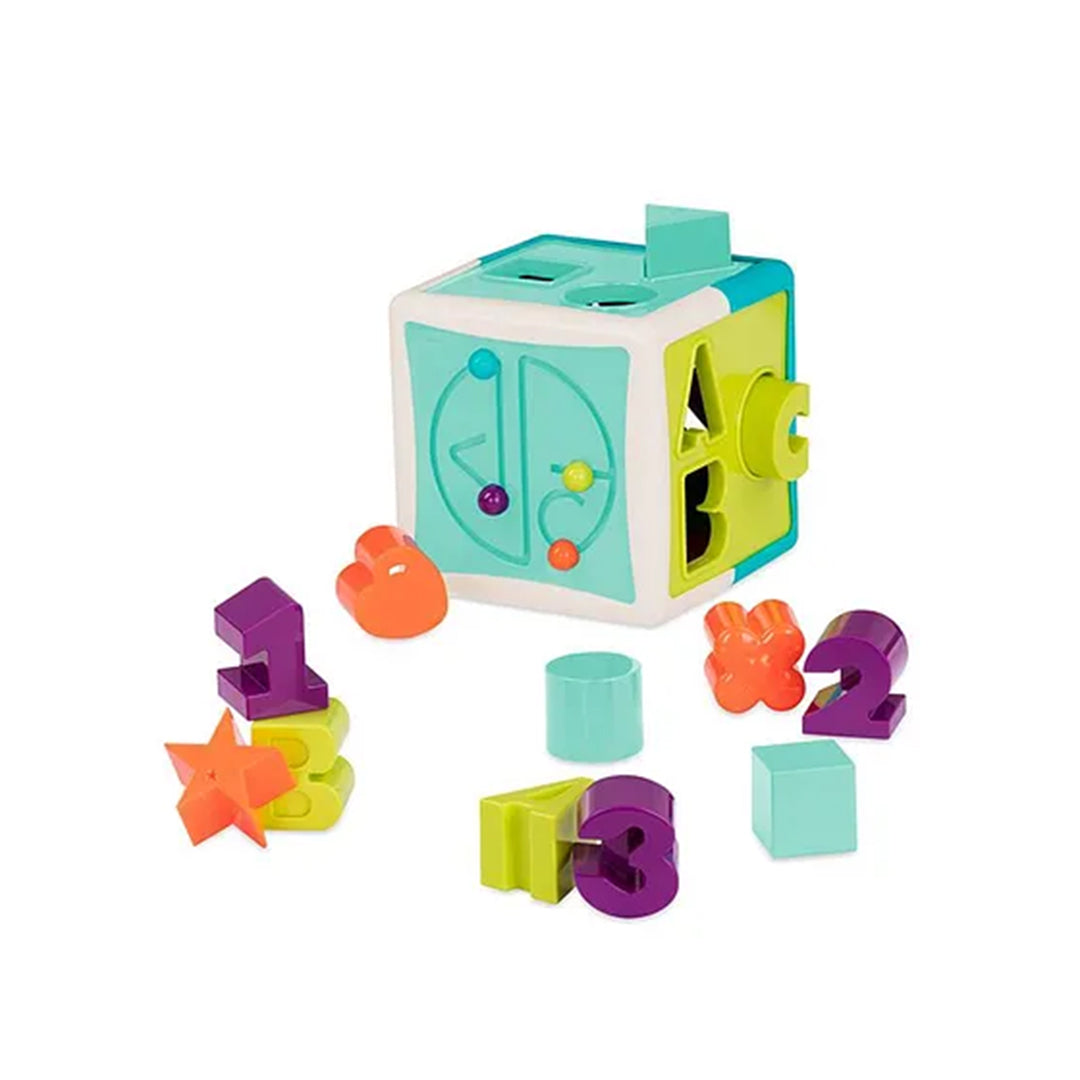 A close-up of a toddler's hands pushing a yellow star block into the Battat Shape Sorter Cube, developing fine motor skills and problem-solving abilities.